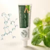 Tube de dentifrice Mahinature entouré de feuilles de menthe symbole de naturalité